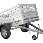 Kippbarer PKW Anhänger beim Transport von Baumaterial